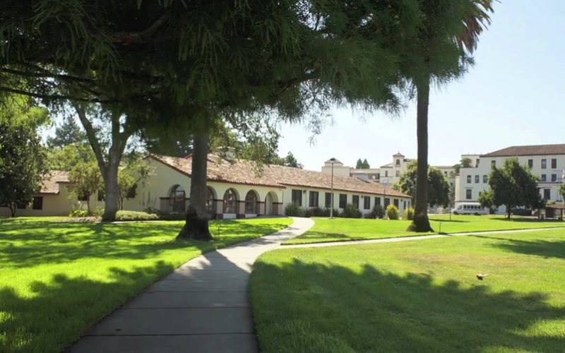 a wide angle photograph of the Yountville veterans home with a large field of grass in the foreground